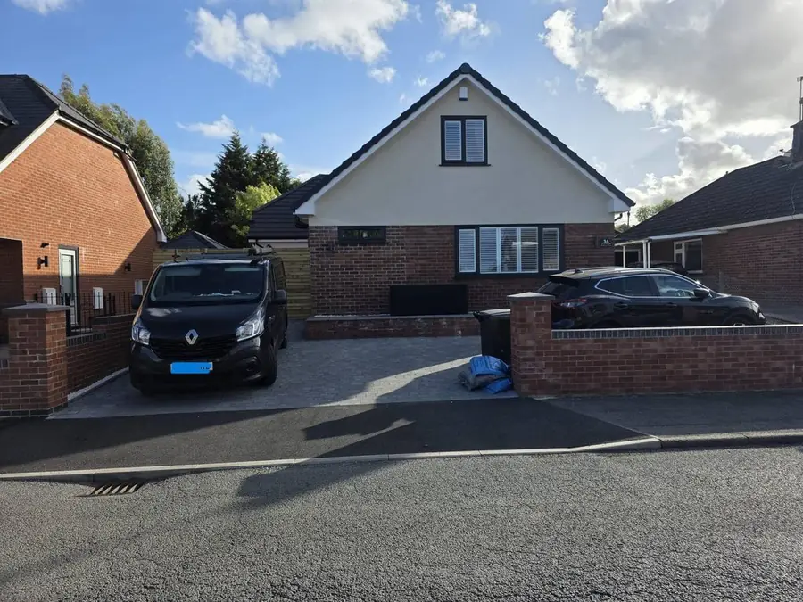 The same Hawarden bungalow after conversion to a 1.5-storey home with rendered gable and new driveway